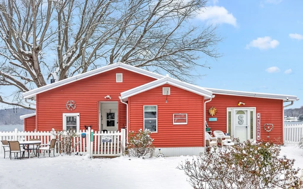 Red lakefront home at 9405 E Southshore Dr on Lake Lemon after a snowfall