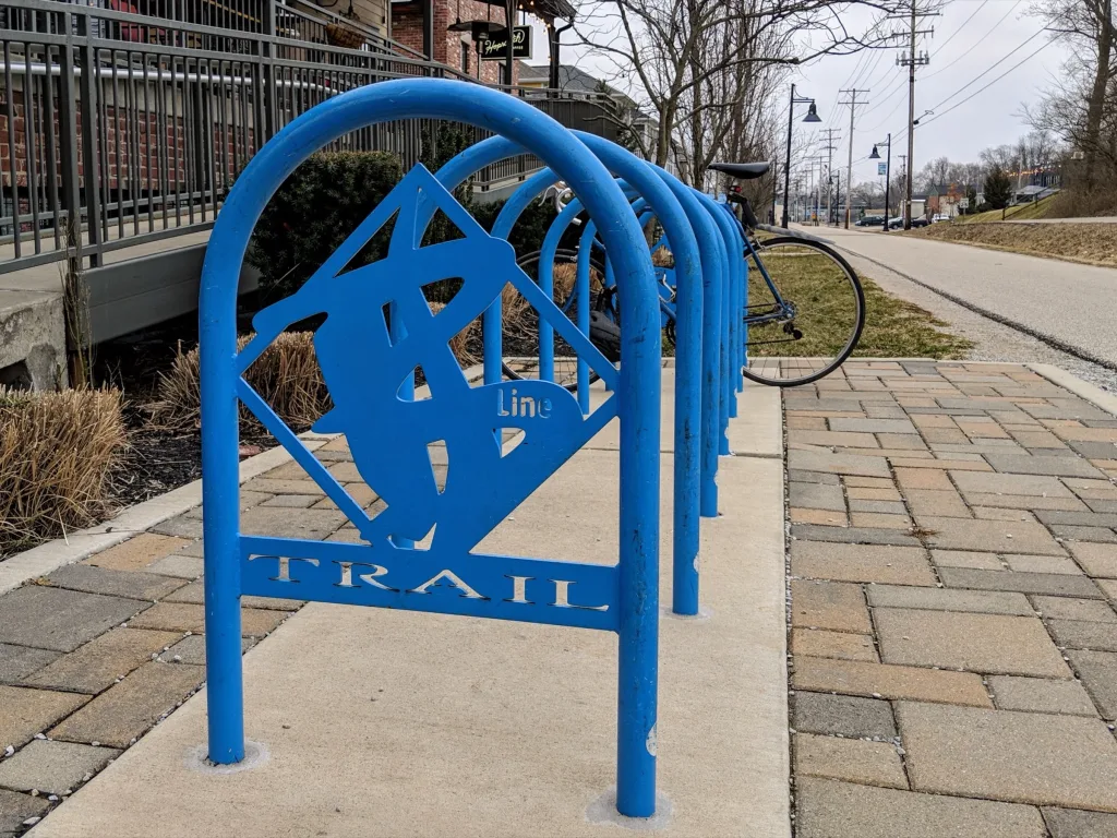 Blue B-Line Trail bike racks with a bicycle parked beside the paved trail in downtown Bloomington