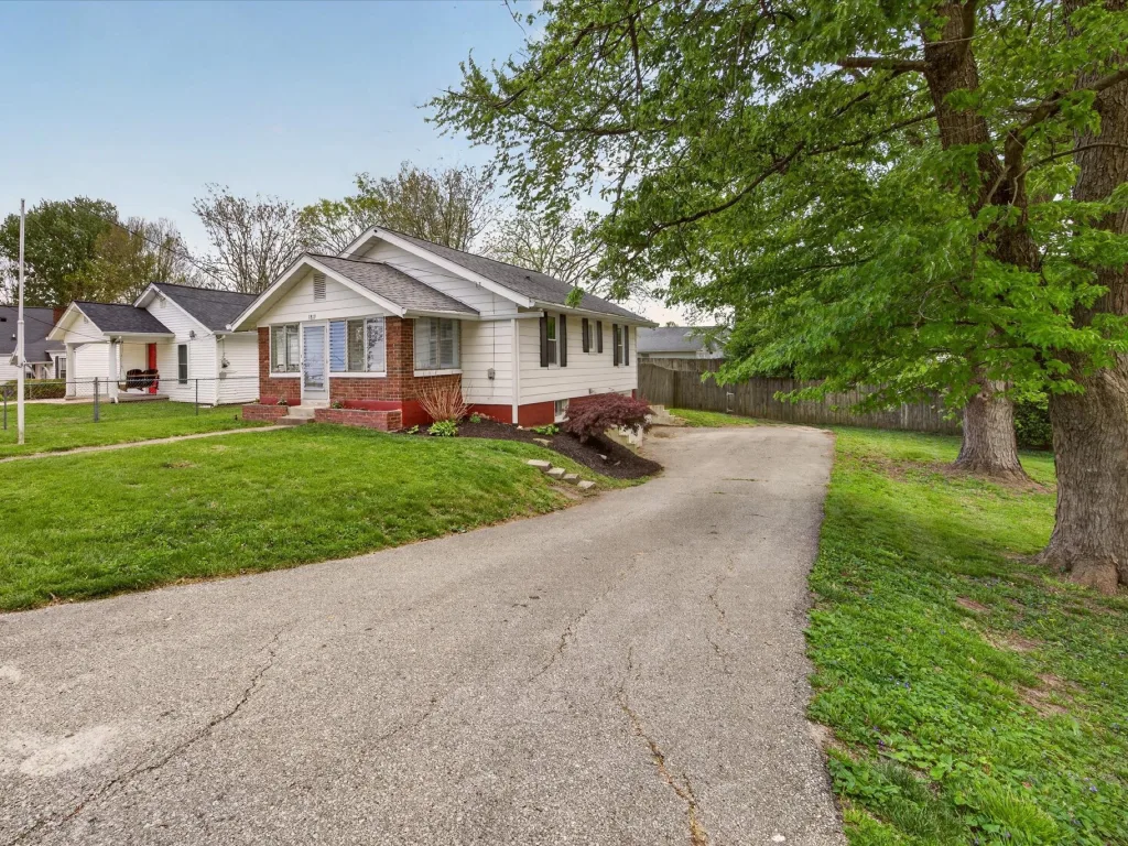 Bungalow with a long driveway and mature trees on Bloomington's west side