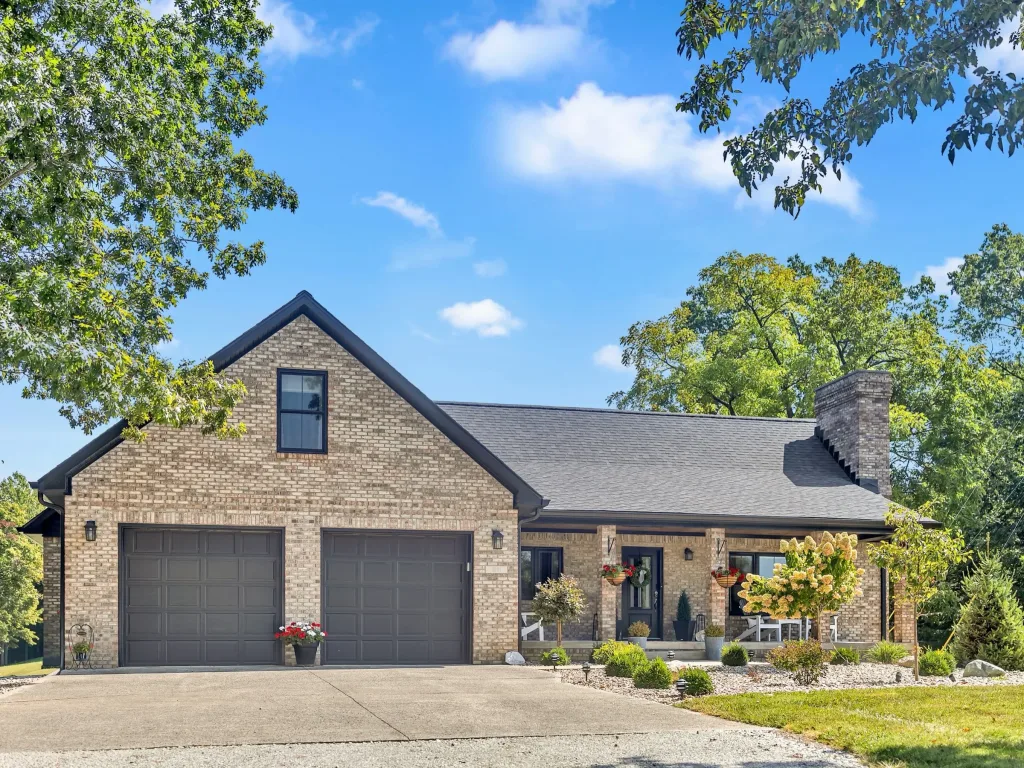 Brick and stone country home with a two-car garage, covered front porch and landscaped yard near Lake Lemon